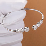 Silver bracelet with embedded stones on a white surface