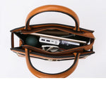 Brown leather handbag with interior compartments on a white background
