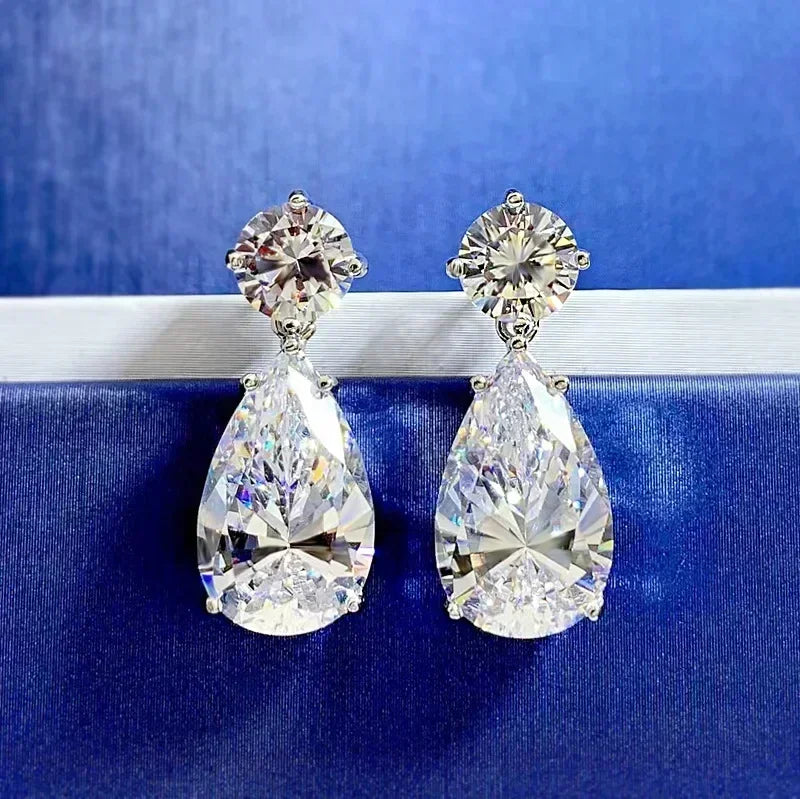 Pair of teardrop-shaped diamond earrings on a blue background