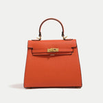 Orange handbag with gold hardware on a light gray background