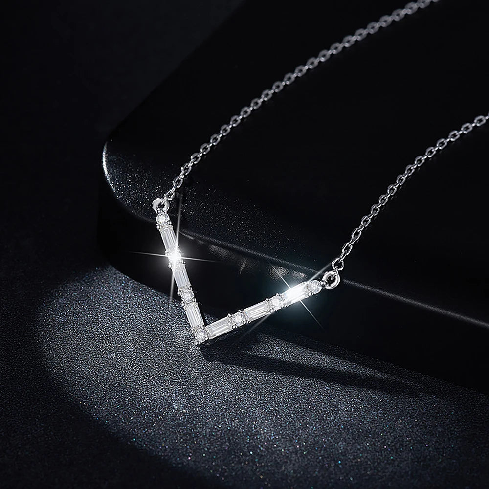 Silver necklace with a V-shaped pendant on a dark background