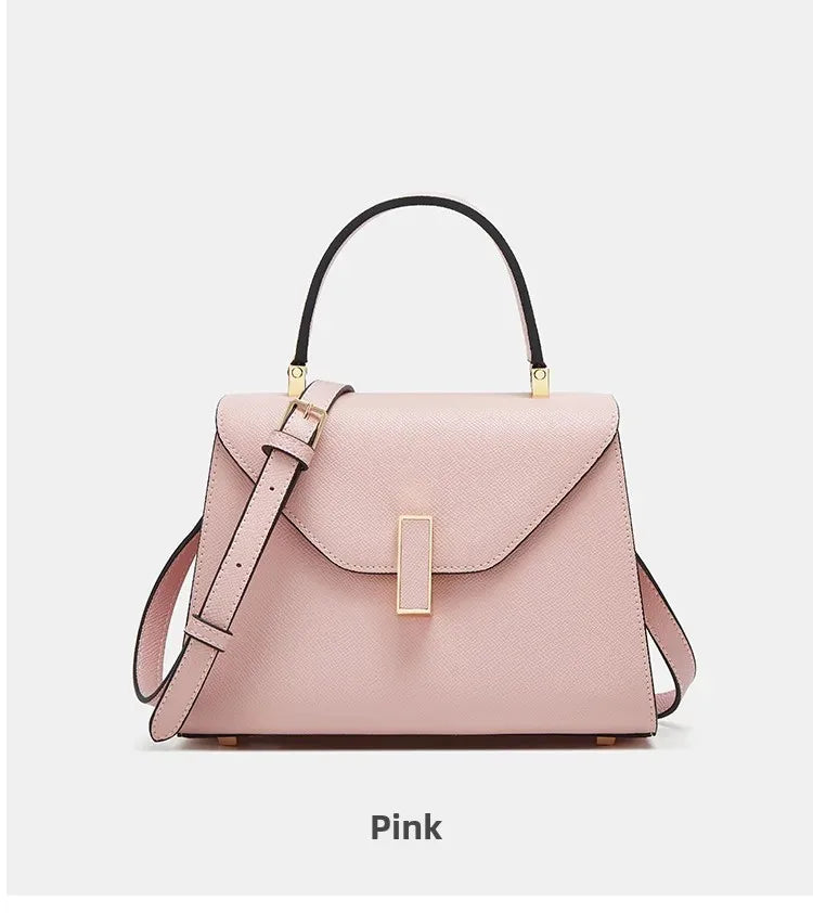 Pink handbag with gold accents on a light gray background