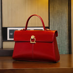 Red handbag with gold accents on a wooden surface