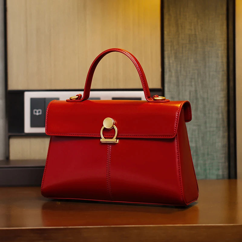Red handbag with gold accents on a wooden surface
