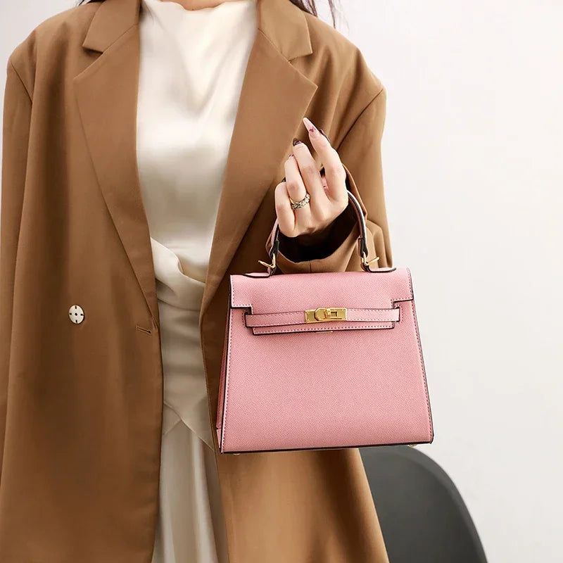 Person holding a pink handbag with a neutral background
