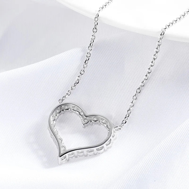 Silver heart-shaped necklace on a white fabric background