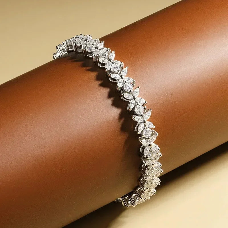 Silver bracelet with clear stones on a wrist against a beige background