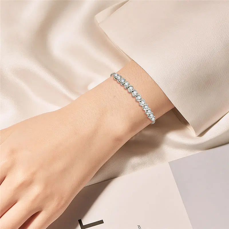 Silver bracelet on a wrist with a soft beige background