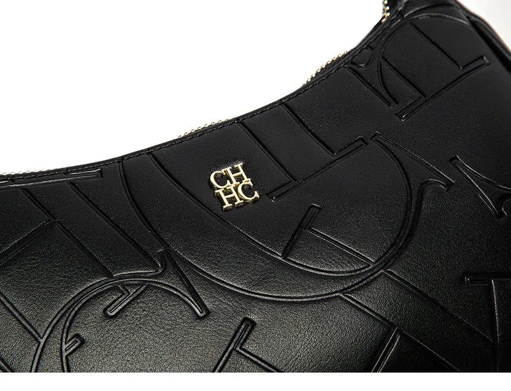 Black leather handbag with embossed design and gold logo on a white background
