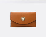 Brown leather clutch with decorative clasp on a white background