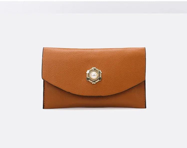Brown leather clutch with decorative clasp on a white background