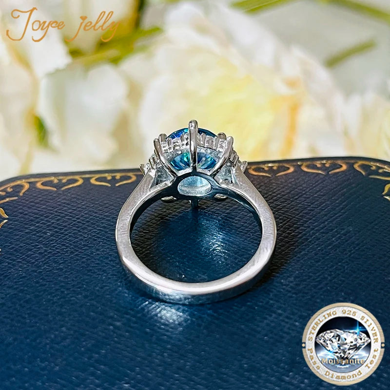 Silver ring with blue gemstone on a textured surface with floral background
