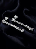 Silver earring set on a dark fabric background