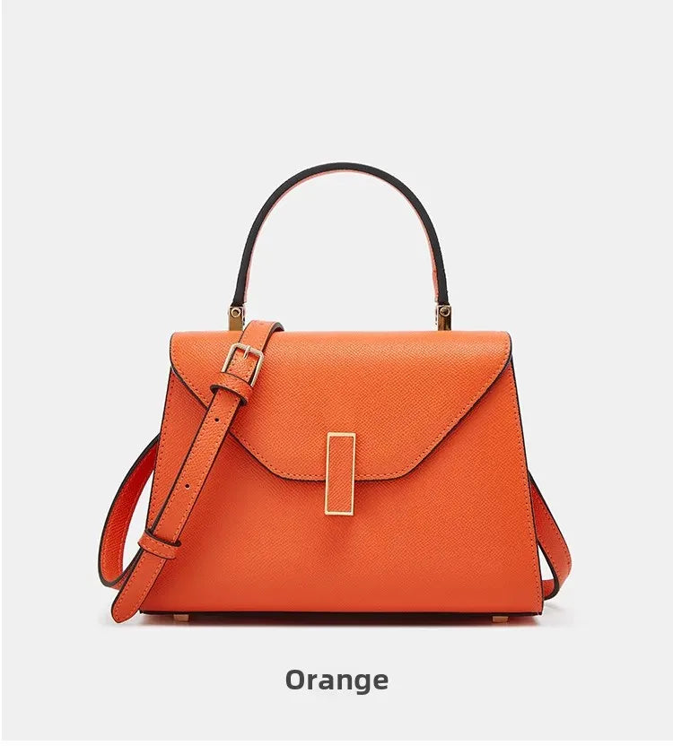 Orange handbag with a strap on a light gray background