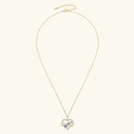 Gold necklace with a heart-shaped pendant on a white background