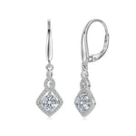 Pair of silver earrings with clear gemstones on a white background