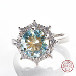 Silver ring with a large gemstone and smaller stones on a white background