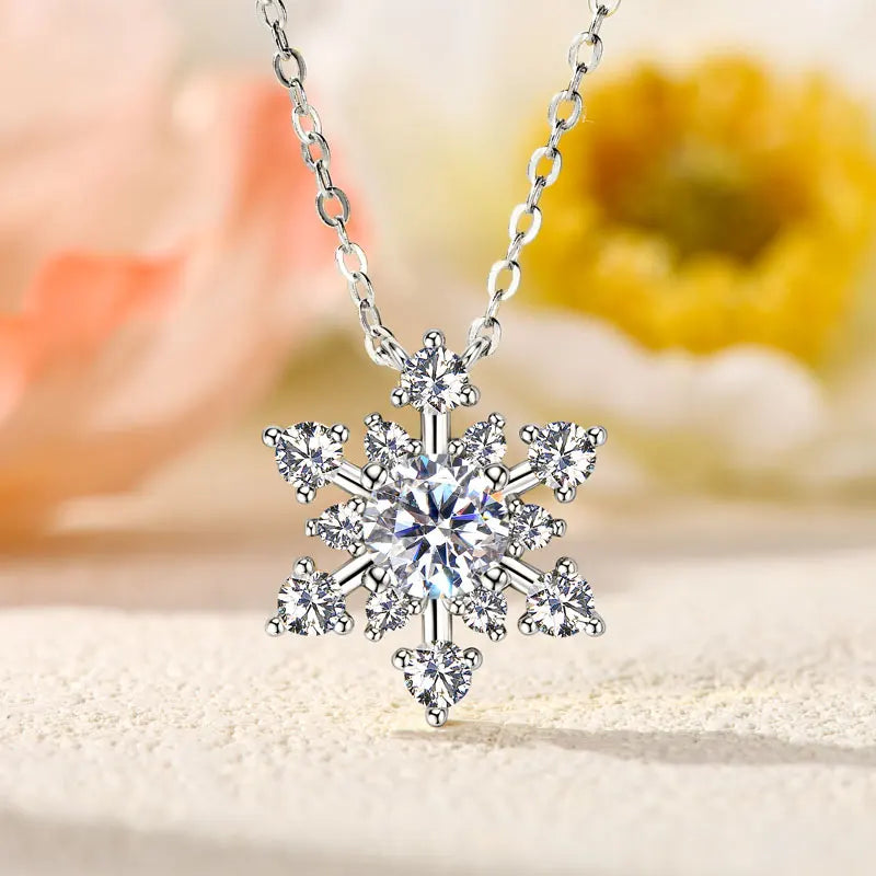 Silver snowflake pendant necklace on a blurred floral background