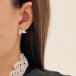 Close-up of a person wearing a decorative earring with a blurred background