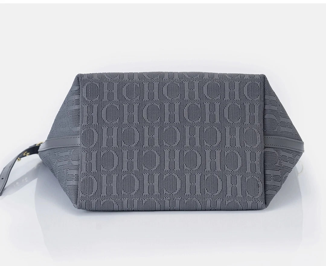 Gray clutch bag with a textured pattern on a light gray background