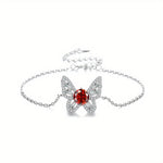 Butterfly-shaped bracelet with a red gemstone on a white background