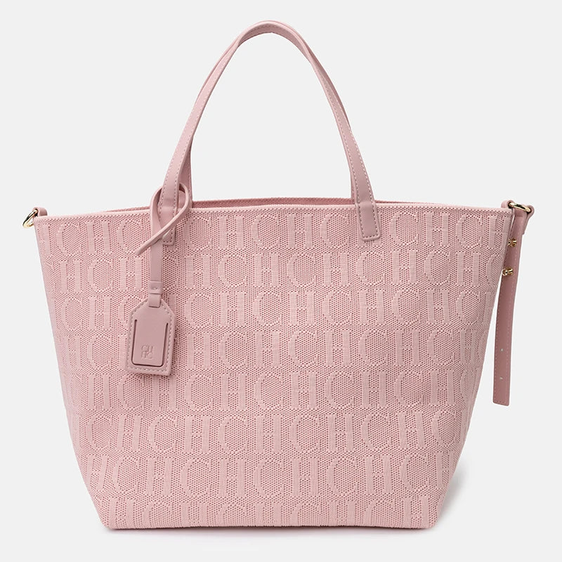 Pink tote bag with a monogram pattern on a light gray background