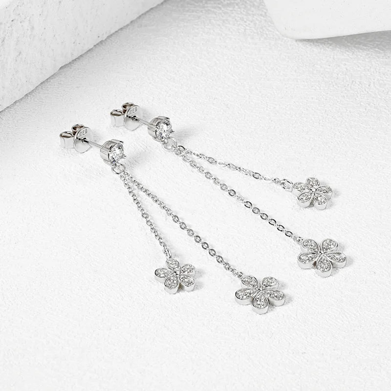 Silver earrings with floral designs on a white background