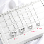 Heart-shaped diamond pendants on a white display with measurements.