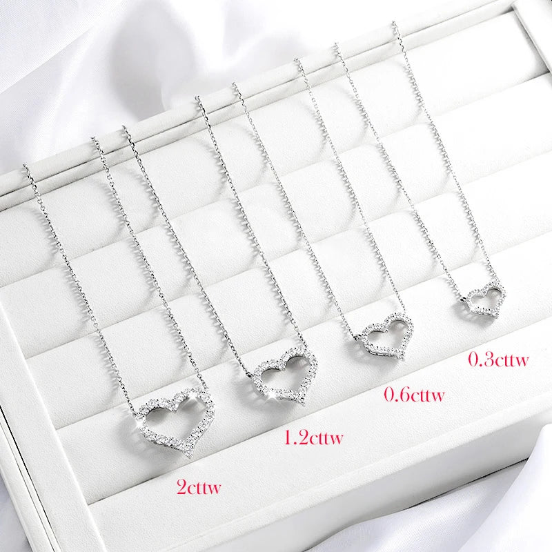 Heart-shaped diamond pendants on a white display with measurements.