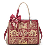 Red handbag with gold patterns and a matching bow on a white background