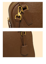 Close-up of a brown leather bag with gold hardware on a beige background