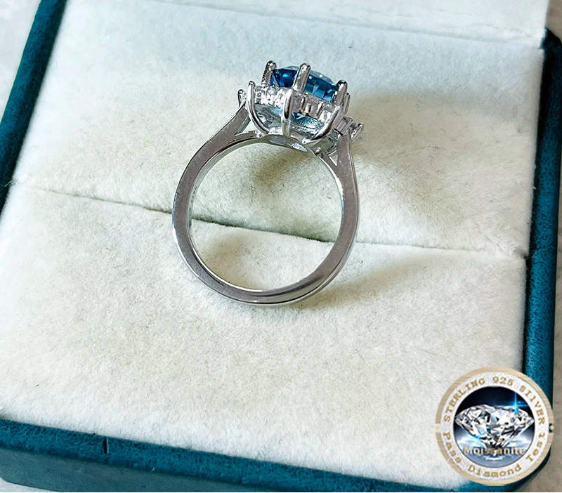 Silver ring with blue gemstone in a jewelry box, featuring the brand 'Joyce Jelly'.