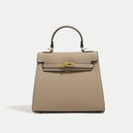 Beige handbag with gold hardware on a light gray background