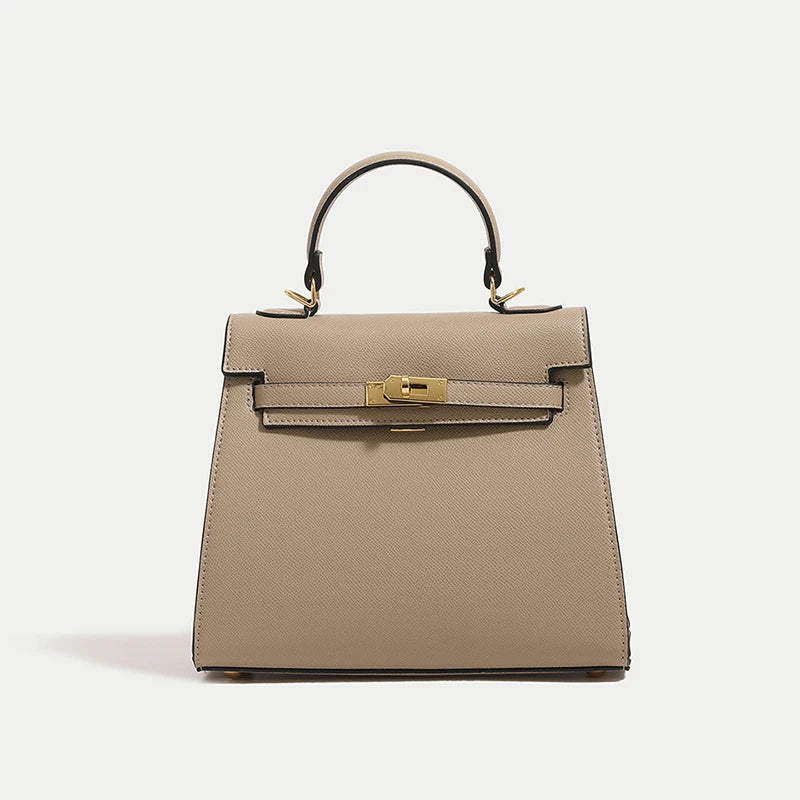 Beige handbag with gold hardware on a light gray background