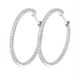 Silver hoop earrings with clear gemstones on a white background