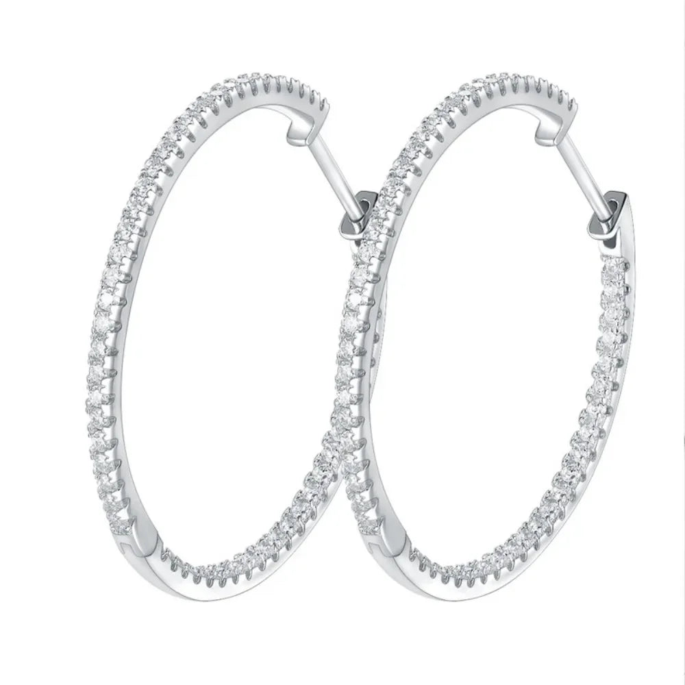 Silver hoop earrings with clear gemstones on a white background