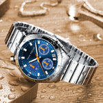 Silver watch with a blue face on a wet wooden surface