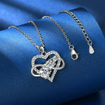Silver heart-shaped necklace with a clasp on a blue fabric background