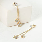 Gold floral earrings with chain on a white background