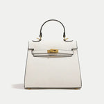 White handbag with gold hardware on a light gray background