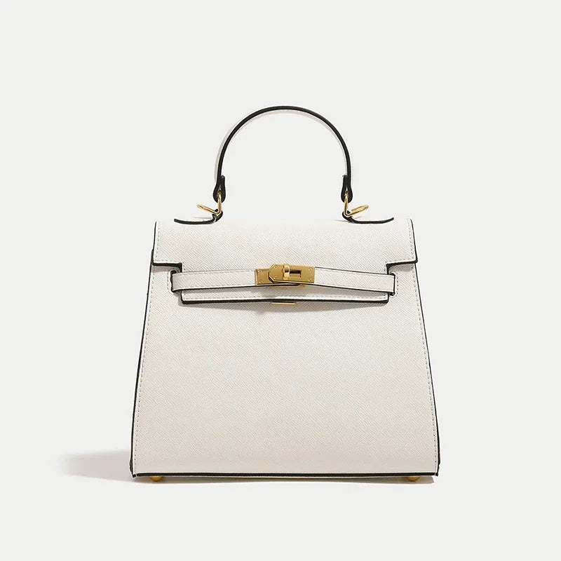 White handbag with gold hardware on a light gray background
