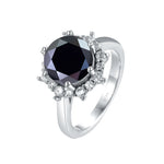 Silver ring with a black gemstone and diamond accents on a white background