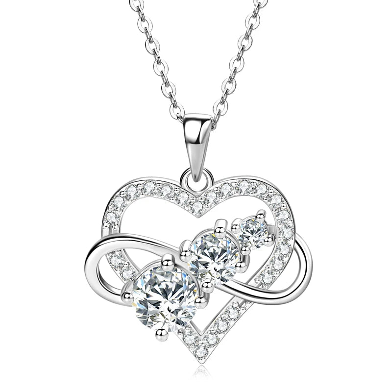 Heart-shaped silver necklace with clear gemstones on a white background