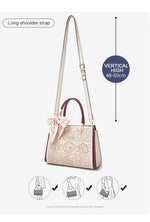 Handbag with a long shoulder strap and decorative elements on a white background