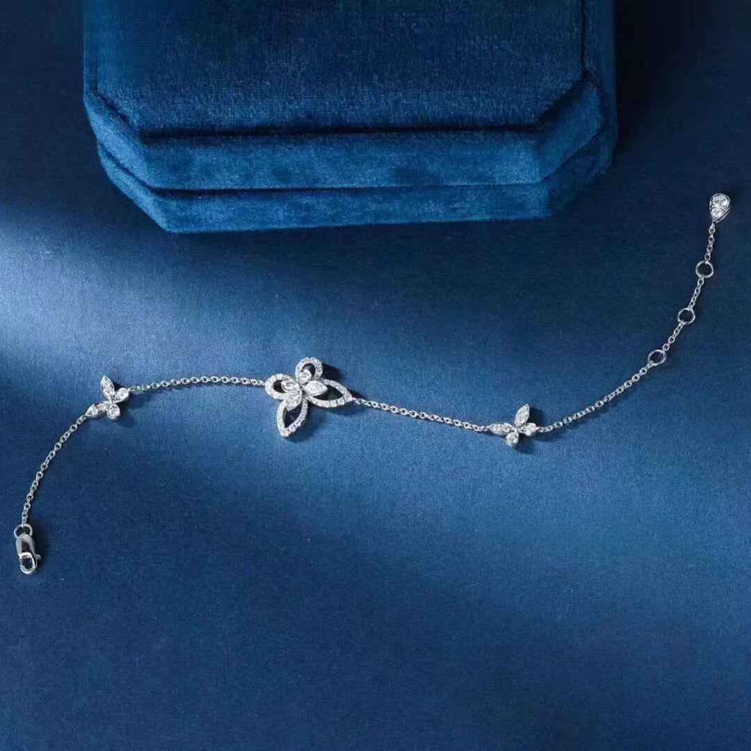 Silver bracelet with floral designs on a blue background