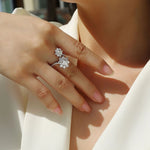 Close-up of a hand wearing a diamond ring on a blurred background