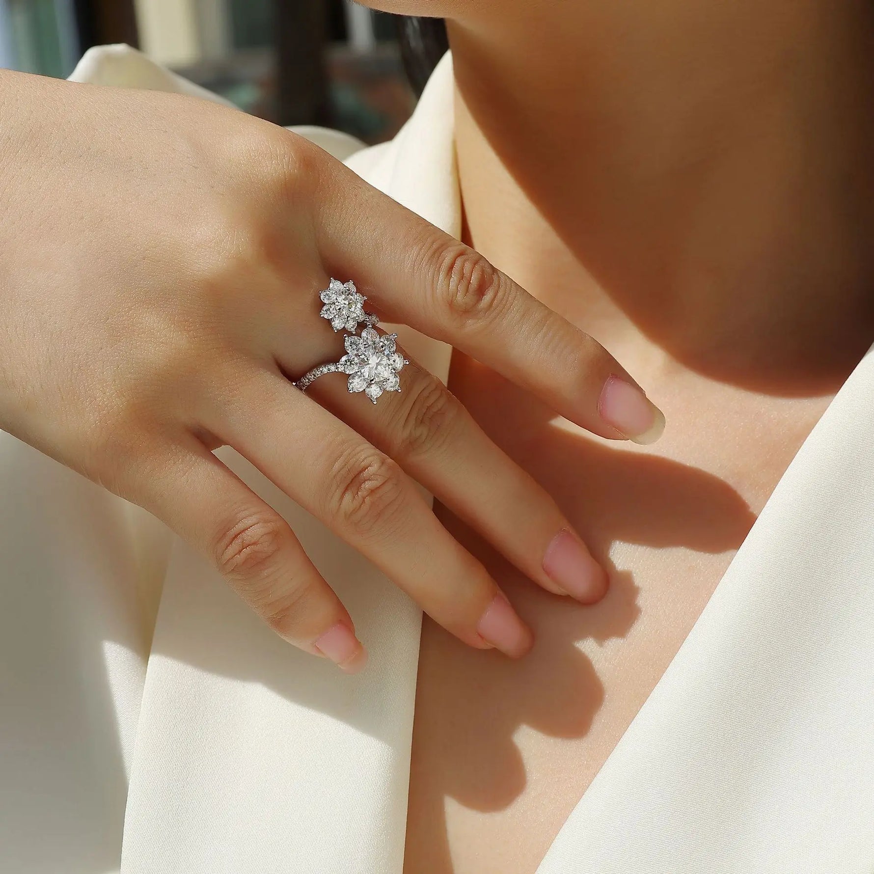 Close-up of a hand wearing a diamond ring on a blurred background