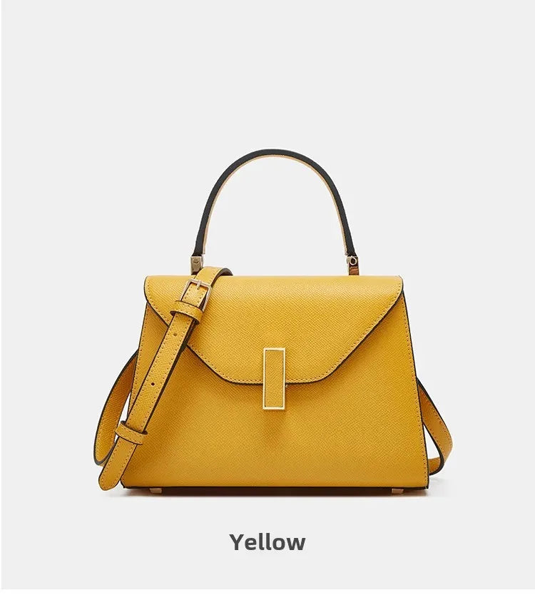 Yellow handbag with a strap on a light gray background