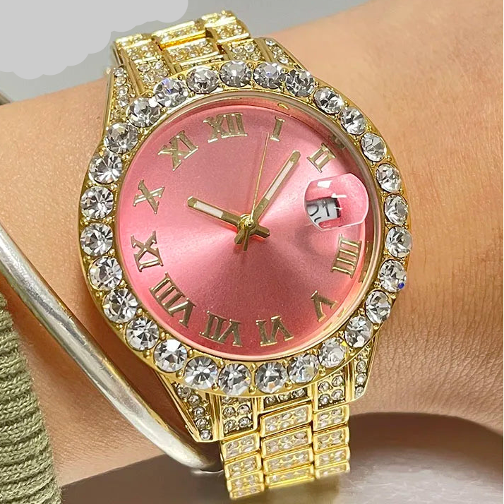 Gold watch with pink face and diamond accents on a wrist