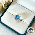 Blue gemstone ring in a jewelry box with 'Joyeux' branding.